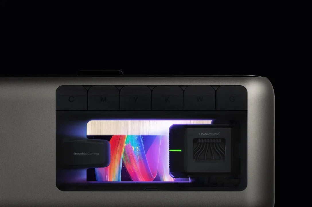 Close-up of a sleek UV printer showing CMYK ink section and vivid color printing under LED light.