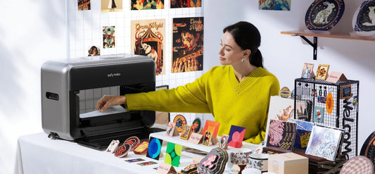A person using the eufyMake E1 UV printer at a creative desk surrounded by colorful printed artworks and crafts.